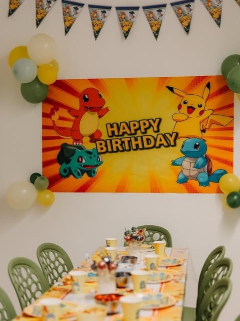 Geburtstagstisch bei Kunterbunt mit Pokémon-Banner, Ballongirlande und gedeckten Plätzen